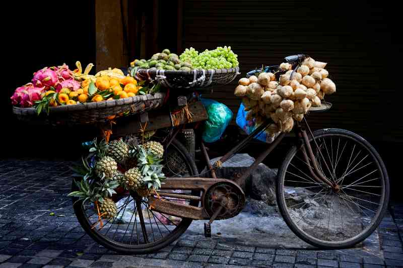 Comida a la venta en una calle lateral en Hanoi, Vietnam. El fotógrafo estaba de vacaciones familiares cuando se encontró con esta vieja bicicleta llena de frutas. Dijo que los colores contra el fondo oscuro y la vieja bicicleta oxidada lo hacían destacar realmente